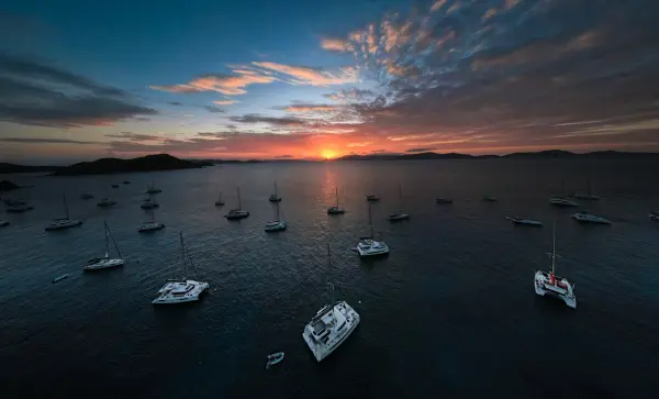 Panoramic aerial view of catamarans at sunset.